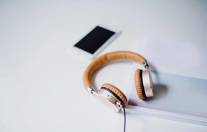 A pair of headphones on a table with a phone